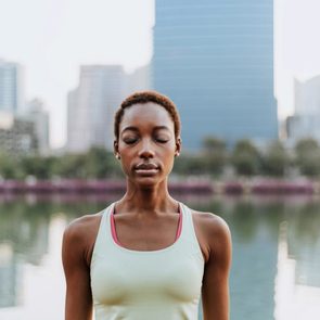 young woman making a meditation at a park