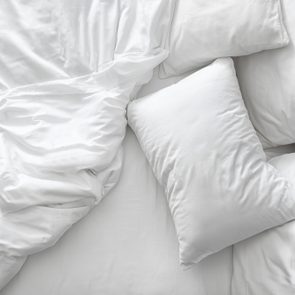 Comfortable bed with white linen at home