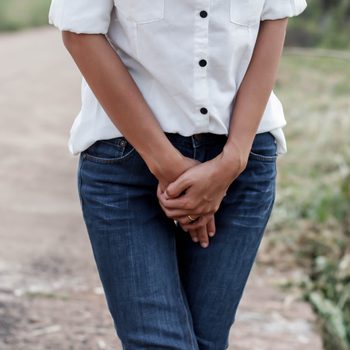 woman with hands holding her crotch