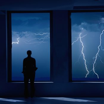 Man standing in window during storm.