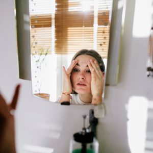 Woman looking in bathroom mirror