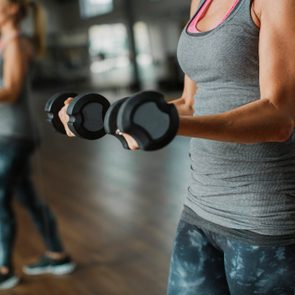 Woman exercising with dumbbells in gym