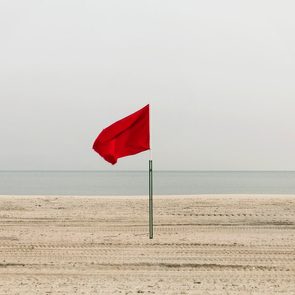 Red flag on empty beach, Coney Island, Brooklyn, New York, USA