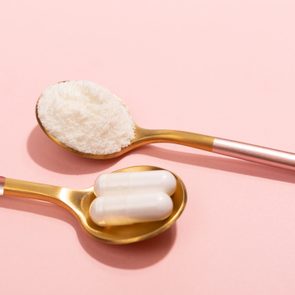 Collagen powder and pills on pink background