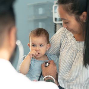 Male pediatrician checks heart of baby girl in medical appointment