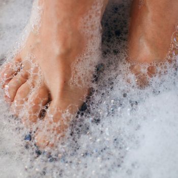 Close Up Of A Woman's Feet Covered In Soap Suds